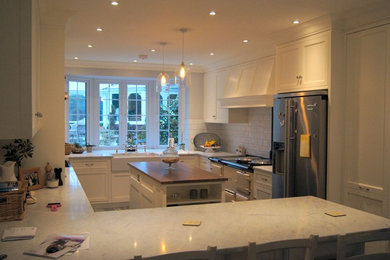 ケントにあるラグジュアリーなトラディショナルスタイルのおしゃれなキッチン (シェーカースタイル扉のキャビネット、大理石カウンター、白いキッチンパネル、セラミックタイルのキッチンパネル) の写真