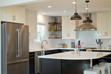 Inspiration for a mid-sized industrial l-shaped medium tone wood floor and orange floor eat-in kitchen remodel in Raleigh with a single-bowl sink, shaker cabinets, black cabinets, quartz countertops, white backsplash, ceramic backsplash, stainless steel appliances, an island and white countertops