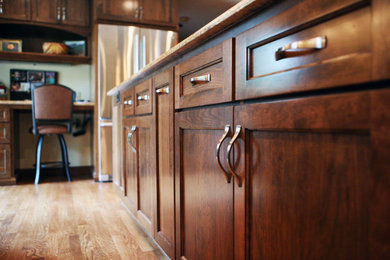 Foto de cocina comedor de estilo americano grande con armarios estilo shaker, puertas de armario de madera en tonos medios, encimera de mármol, electrodomésticos de acero inoxidable, suelo de madera oscura y una isla