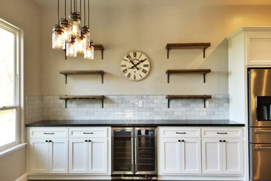 Example of a dark wood floor eat-in kitchen design in Sacramento with flat-panel cabinets, white cabinets, concrete countertops, gray backsplash, glass tile backsplash and stainless steel appliances