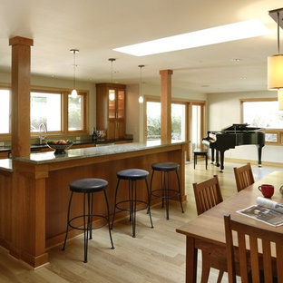 Large traditional eat-in kitchen appliance - Large elegant single-wall light wood floor and beige floor eat-in kitchen photo in Portland with glass-front cabinets, medium tone wood cabinets, granite countertops and an island