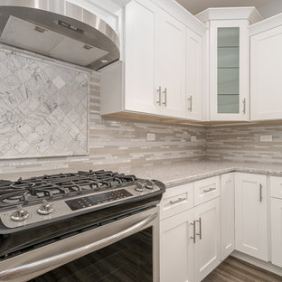 Foto di una grande cucina tradizionale con lavello sottopiano, ante bianche, elettrodomestici in acciaio inossidabile, ante con riquadro incassato, top alla veneziana, paraspruzzi grigio, paraspruzzi con piastrelle a listelli, parquet chiaro, pavimento grigio e top grigio