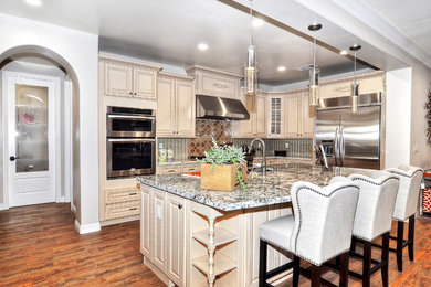 Mid-sized transitional galley medium tone wood floor eat-in kitchen photo in Los Angeles with granite countertops, metallic backsplash, stainless steel appliances, an island, a farmhouse sink, raised-panel cabinets, light wood cabinets and metal backsplash