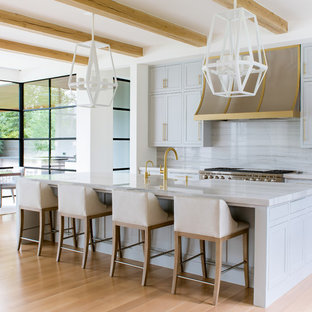 Huge mediterranean eat-in kitchen pictures - Example of a huge tuscan light wood floor and beige floor eat-in kitchen design in Dallas with blue cabinets, stone slab backsplash, an island, shaker cabinets, gray backsplash, stainless steel appliances and gray countertops