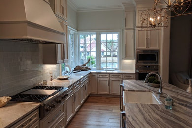 Exempel på ett stort klassiskt kök, med en rustik diskho, luckor med infälld panel, rostfria vitvaror och en köksö