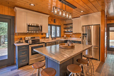 Kitchen - mid-sized rustic l-shaped medium tone wood floor and brown floor kitchen idea in Boise with a farmhouse sink, recessed-panel cabinets, gray cabinets, stainless steel countertops, an island and gray countertops