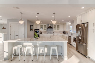 Inspiration for a large coastal l-shaped laminate floor and multicolored floor open concept kitchen remodel in Wilmington with an undermount sink, shaker cabinets, gray cabinets, quartz countertops, gray backsplash, porcelain backsplash, stainless steel appliances, an island and white countertops
