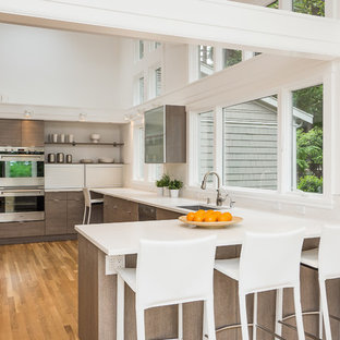 Contemporary kitchen photos - Example of a trendy u-shaped kitchen design in Seattle with a drop-in sink, flat-panel cabinets, dark wood cabinets and stainless steel appliances