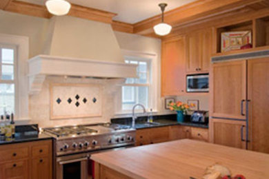 Example of an arts and crafts u-shaped medium tone wood floor eat-in kitchen design in Seattle with an undermount sink, recessed-panel cabinets, light wood cabinets and an island