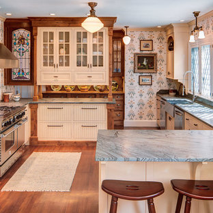 Foto di una cucina ad U tradizionale con lavello stile country, ante lisce, ante beige, paraspruzzi beige, elettrodomestici in acciaio inossidabile e top blu