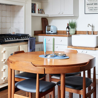 Inspiration for a small bohemian kitchen/diner in London with a belfast sink, wood worktops, coloured appliances, medium hardwood flooring, no island, brown worktops, recessed-panel cabinets, grey cabinets and multi-coloured splashback.