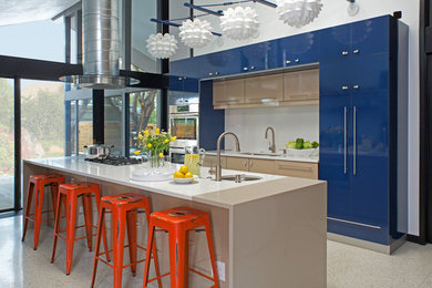 Ejemplo de cocina contemporánea con fregadero bajoencimera, armarios con paneles lisos, puertas de armario azules, salpicadero blanco, electrodomésticos de acero inoxidable y una isla