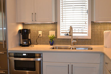 Inspiration for a small modern l-shaped dark wood floor eat-in kitchen remodel in Columbus with an undermount sink, recessed-panel cabinets, yellow cabinets, quartz countertops, green backsplash, glass tile backsplash, stainless steel appliances and an island