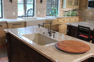 Exempel på ett stort modernt kök, med en integrerad diskho, luckor med infälld panel, skåp i ljust trä, bänkskiva i kvartsit, integrerade vitvaror, mellanmörkt trägolv, beige stänkskydd, stänkskydd i sten, flera köksöar och brunt golv