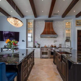 Mediterranean kitchen designs - Tuscan u-shaped brown floor and exposed beam kitchen photo in Charlotte with a farmhouse sink, raised-panel cabinets, white cabinets, gray backsplash, stainless steel appliances, two islands and black countertops