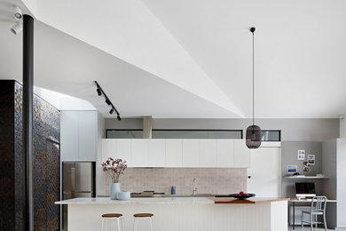Example of a mid-sized trendy galley eat-in kitchen design in Melbourne with white cabinets, marble countertops, red backsplash, ceramic backsplash, stainless steel appliances, an island and white countertops