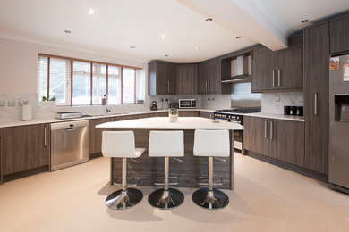 Photo of a large contemporary grey and cream u-shaped kitchen/diner in Berkshire with a built-in sink, flat-panel cabinets, composite countertops, white splashback, stainless steel appliances, ceramic flooring, an island, beige floors and white worktops.