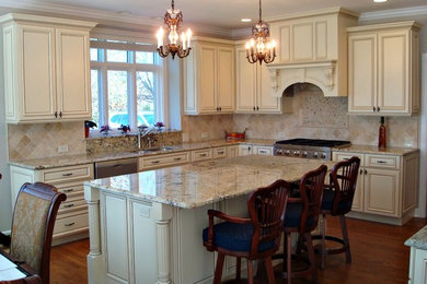 Example of a large trendy kitchen design in Chicago with raised-panel cabinets and an island