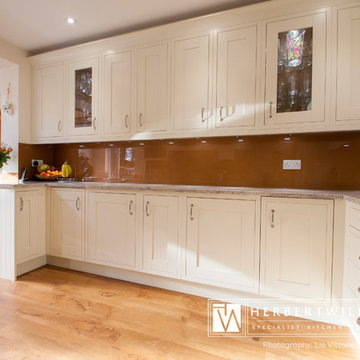Ivory Mackintosh kitchen with stunning copper glass splashback
