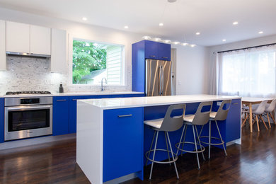 Foto di una cucina minimal di medie dimensioni con ante lisce, ante blu, top in quarzite, paraspruzzi in marmo, elettrodomestici in acciaio inossidabile, parquet scuro, top bianco, paraspruzzi multicolore e pavimento marrone