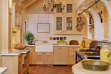 Kitchen - farmhouse u-shaped brown floor kitchen idea in St Louis with a farmhouse sink, shaker cabinets, light wood cabinets, white backsplash and white countertops