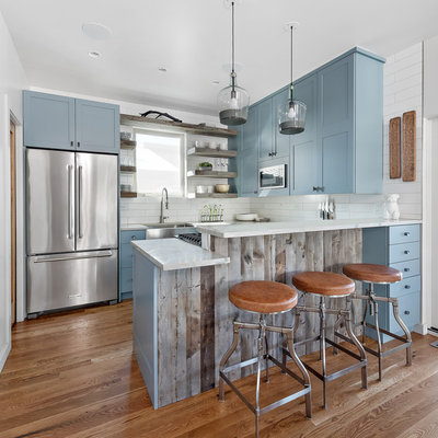 Eat-in kitchen - large rustic l-shaped medium tone wood floor and brown floor eat-in kitchen idea in Other with an undermount sink, shaker cabinets, blue cabinets, marble countertops, white backsplash, subway tile backsplash, stainless steel appliances and a peninsula