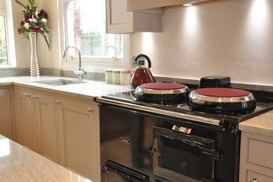 Mittelgroße Klassische Küche mit Schrankfronten im Shaker-Stil, grauen Schränken, Granit-Arbeitsplatte, Küchengeräten aus Edelstahl, Kücheninsel und Kalkstein in Cheshire