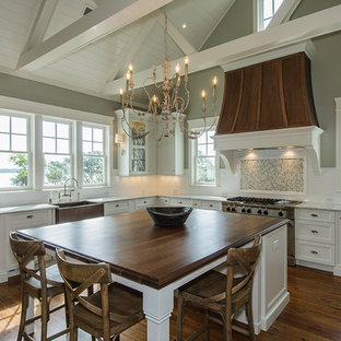 Kitchen - traditional kitchen idea in Charleston with a farmhouse sink, wood countertops, recessed-panel cabinets and white cabinets