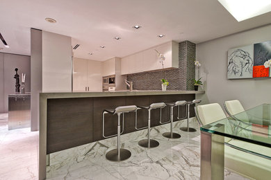 Inspiration for a small contemporary l-shaped marble floor eat-in kitchen remodel in Miami with a single-bowl sink, raised-panel cabinets, white cabinets, marble countertops, brown backsplash, mosaic tile backsplash and stainless steel appliances