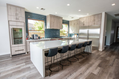 Inspiration for a large transitional l-shaped vinyl floor and brown floor kitchen pantry remodel in Phoenix with an undermount sink, flat-panel cabinets, light wood cabinets, quartzite countertops, blue backsplash, subway tile backsplash, stainless steel appliances, two islands and white countertops