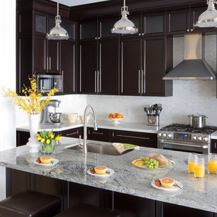 Esempio di una cucina chic con lavello sottopiano, ante in stile shaker, ante in legno bruno, paraspruzzi bianco e elettrodomestici in acciaio inossidabile