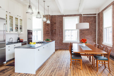 ニューヨークにあるコンテンポラリースタイルのおしゃれなキッチン (アンダーカウンターシンク、ガラス扉のキャビネット、白いキャビネット、白いキッチンパネル、シルバーの調理設備) の写真