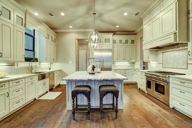 Example of a large u-shaped kitchen design in Houston with recessed-panel cabinets and an island