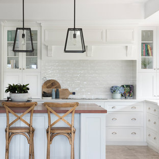 Large traditional l-shaped kitchen in Other with shaker cabinets, white cabinets, white splashback, with island, beige floor, white benchtop and subway tile splashback.