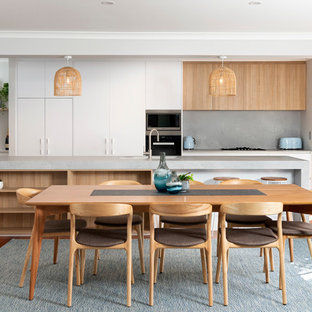 This is an example of a contemporary galley eat-in kitchen in Perth with an undermount sink, flat-panel cabinets, white cabinets, grey splashback, stainless steel appliances, medium hardwood floors, with island, brown floor and grey benchtop.