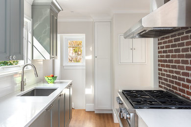 Inspiration for a mid-sized transitional galley medium tone wood floor and brown floor eat-in kitchen remodel in Vancouver with an undermount sink, recessed-panel cabinets, gray cabinets, quartz countertops, white backsplash, paneled appliances, a peninsula, white countertops and ceramic backsplash