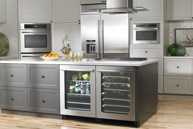 Foto de cocina comedor contemporánea de tamaño medio con electrodomésticos de acero inoxidable, suelo de madera clara y una isla