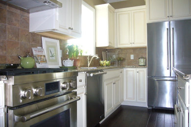Mid-sized elegant l-shaped eat-in kitchen photo in Philadelphia with raised-panel cabinets, stainless steel appliances and an island