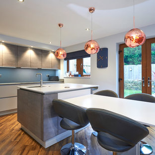 Design ideas for a contemporary galley kitchen/diner in Other with a submerged sink, flat-panel cabinets, grey cabinets, blue splashback, medium hardwood flooring, an island, brown floors and white worktops.