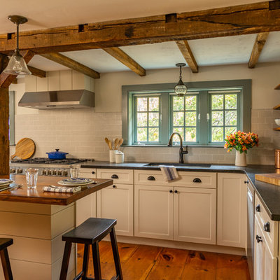 Mid-sized cottage l-shaped medium tone wood floor eat-in kitchen photo in Boston with an undermount sink, shaker cabinets, white cabinets, granite countertops, gray backsplash, ceramic backsplash, stainless steel appliances, an island and black countertops