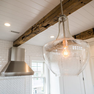 Large farmhouse kitchen pictures - Kitchen - large cottage medium tone wood floor kitchen idea in Charleston with a farmhouse sink, shaker cabinets, white cabinets, quartz countertops, white backsplash, ceramic backsplash, stainless steel appliances, an island and white countertops