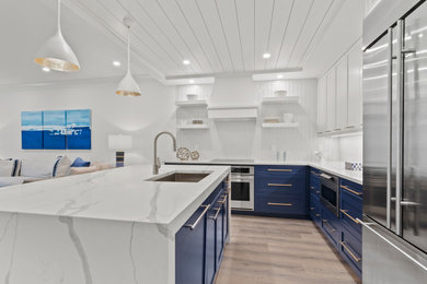 Kitchen - mid-sized coastal l-shaped medium tone wood floor and shiplap ceiling kitchen idea in Other with an undermount sink, shaker cabinets, quartz countertops, white backsplash, mosaic tile backsplash, stainless steel appliances and an island