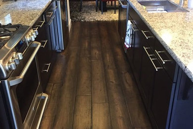 Small trendy galley dark wood floor eat-in kitchen photo in San Francisco with a drop-in sink, beaded inset cabinets, dark wood cabinets, marble countertops, stainless steel appliances and an island