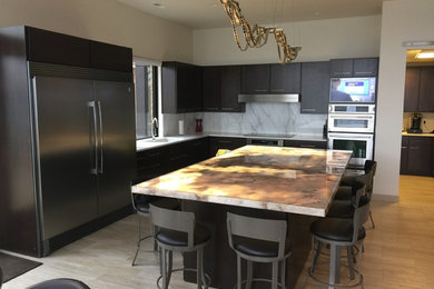 Open concept kitchen - mid-sized transitional l-shaped light wood floor and beige floor open concept kitchen idea in Other with an undermount sink, flat-panel cabinets, dark wood cabinets, marble countertops, white backsplash, marble backsplash, stainless steel appliances and an island