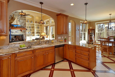 Eat-in kitchen - mid-sized traditional l-shaped porcelain tile and multicolored floor eat-in kitchen idea in Other with raised-panel cabinets, medium tone wood cabinets, granite countertops, beige backsplash, ceramic backsplash, stainless steel appliances, an undermount sink and a peninsula