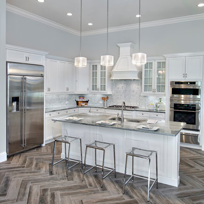 Example of a transitional l-shaped kitchen design in Tampa with an undermount sink, recessed-panel cabinets, white cabinets, multicolored backsplash, stainless steel appliances and an island