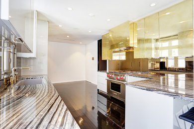 Moderne Wohnküche mit Unterbauwaschbecken, flächenbündigen Schrankfronten, grauen Schränken, Rückwand aus Stein, Küchengeräten aus Edelstahl und Halbinsel in Miami