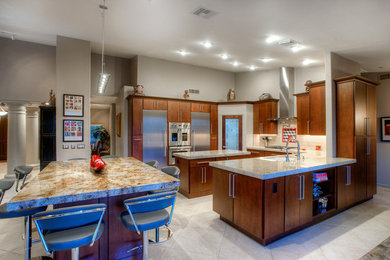 Inspiration for a mid-sized modern u-shaped eat-in kitchen remodel in Phoenix with an undermount sink, flat-panel cabinets, medium tone wood cabinets, granite countertops, beige backsplash, stainless steel appliances and an island