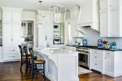Enclosed kitchen - large traditional dark wood floor enclosed kitchen idea in Atlanta with shaker cabinets, white cabinets, marble countertops, white backsplash, subway tile backsplash, stainless steel appliances and an island