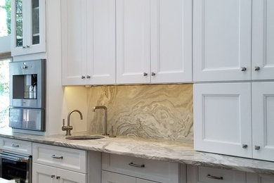 Kitchen - contemporary kitchen idea in Bridgeport with an undermount sink, shaker cabinets, white cabinets, quartzite countertops, stone slab backsplash, stainless steel appliances and an island
